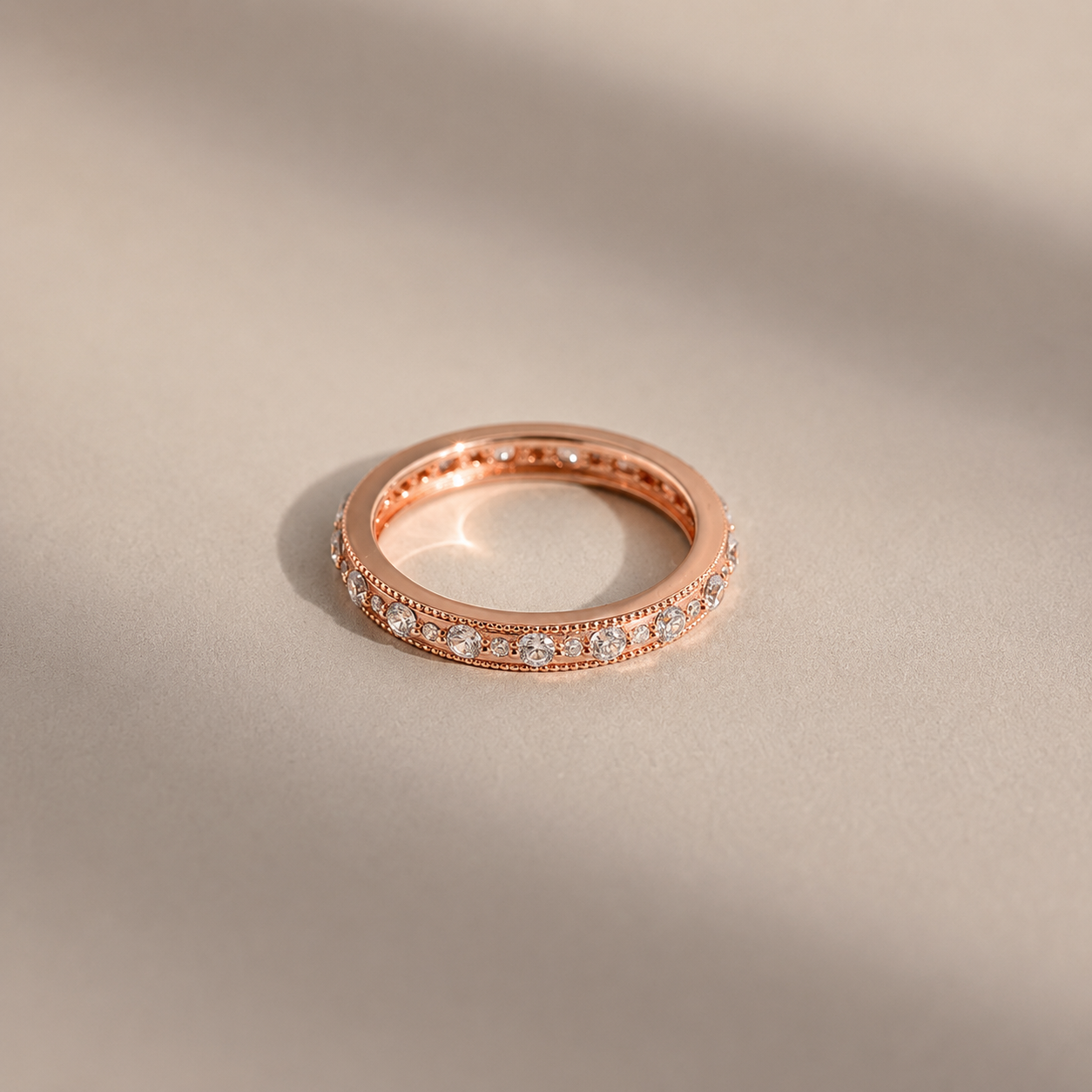 Rose gold ring with diamonds on a beige background